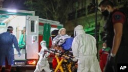 Para petugas medis mengevakuasi seorang lansia dari panti jompo di Buenos Aires, Argentina, setelah beberapa warganya dites positif Covid-19, Kamis, 7 Mei 2020. (AP Photo/Natacha Pisarenko)