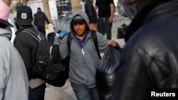 A migrant man, part of a caravan of thousands from Central America tying to reach the United States, carries his belongings in Tijuana, Mexico, Jan. 29, 2019. 