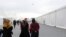 Afghan refugees walk alongside temporary housing in Liberty Village on Joint Base McGuire-Dix- Lakehurst in Trenton, N.J., Dec. 2, 2021.