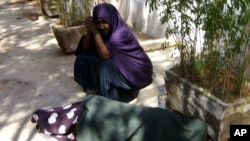 Asha et Muna attendent assistance en dehors du bureau du HCR à la ville de Galkayo. Muna, dort sur le sol parce qu'elle ne pouvait pas résister à la douleur à la cuisse. Elle a été poignardée par un violeur le 26 novembre de 2010.