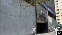 People pass the Archdiocese of New York, in New York, Thursday, Sept. 6, 2018.