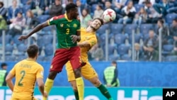 André Frank Zambo Anguissa du Cameroun et Mathew Leckie de l’Australie, à droite, dans un duel aérien lors d’un match du groupe B de la Coupe des Confédérations entre le Cameroun et l’Australie au stade St. Petersburg, Russie, 22 juin 2017.