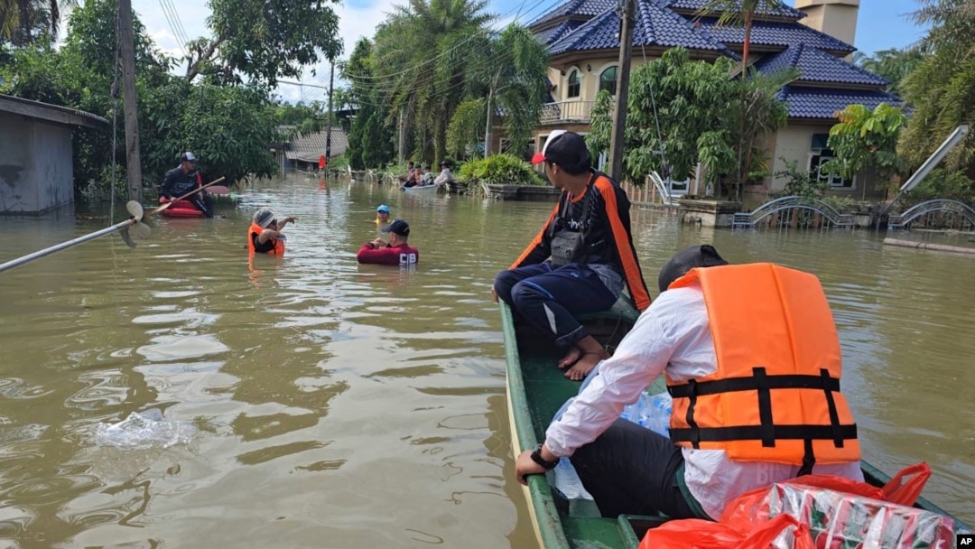 Thai rescuers offer food to flood affected people in Narathiwat province, southern Thailand, Dec. 3, 2024. 