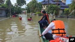 Para petugas SAR menyalurkan makanan untuk sejumlah warga yang terdampak banjir di Provinsi Narathiwat, selatan Thailand, Selatan, 3 Desember 2024. (Kriya Tehtanee/AP)