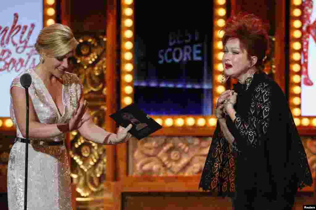 Cyndi Lauper enters the stage to accept the award for Best Original Score (Music and/or Lyrics) Written for the Theatre for &quot;Kinky Boots&quot; from Jane Krakowski during the Tony Awards in New York, June 9, 2013.