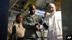 Ibrahim Idris es sacado de un avión a su llegada de Sudán, procedente de la cárcel de Guantánamo.