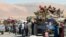 Syrian refugees, fleeing the recent fighting in Arsal, wait by trucks in Majdel Anjar in the Bekaa valley, near the Lebanese border with Syria, Aug. 8, 2014.