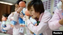 北京一所家政服務培訓學校的學員們正學習如何照看嬰兒（路透社2018年12月5日）