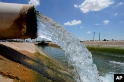 Water from the Colorado River diverted through the Central Arizona Project fills an irrigation canal, Thursday, Aug. 18, 2022, in Maricopa, Ariz. (AP Photo/Matt York)