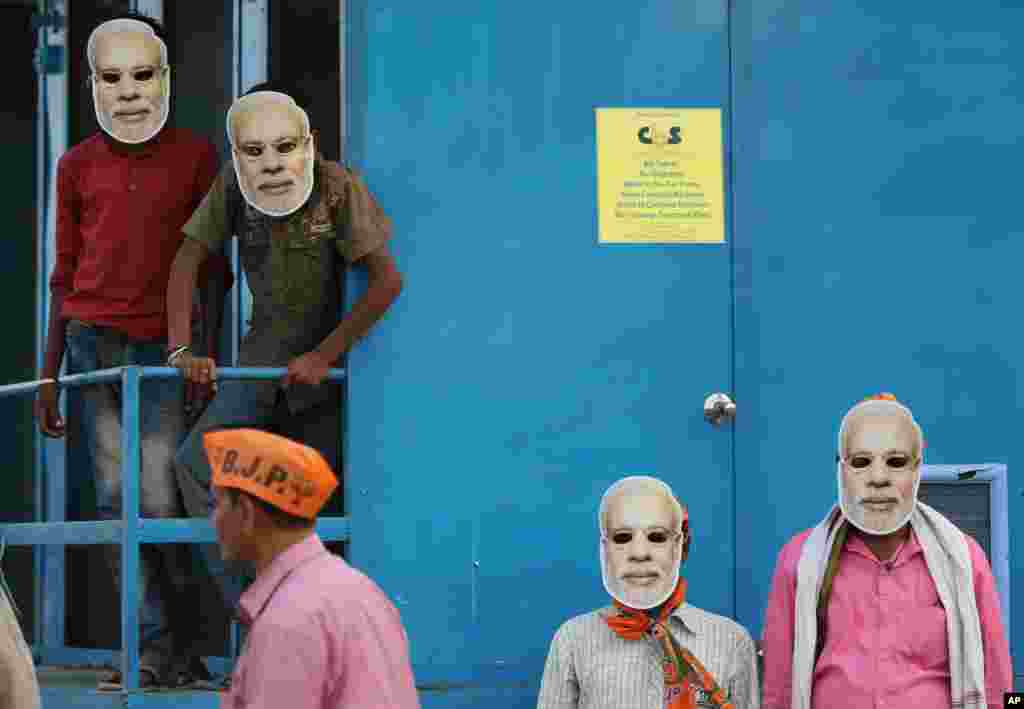Supporters of India's ruling Bharatiya Janata Party (BJP), wearing masks of Prime Minister Narendra Modi, wait for his arrival during an election campaign rally in Prayagraj.