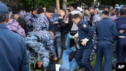 Kazakh police detain a demonstrator during an anti-government protest during the presidential elections in Nur-Sultan, the capital city of Kazakhstan, June 9, 2019. 