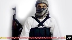 FILE - This image taken from a militant website associated with Islamic State extremists, posted May 23, 2015, purports to show a suicide bomber with the Arabic text below referring to him as a "heroic martyr."
