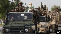 FILE - Pakistani army troops ride military vehicles following an operation launched against a terror group in Karachi, Pakistan, June 16, 2014.