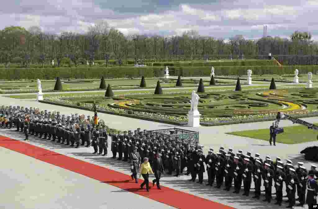 German Chancellor Angela Merkel, left, and U.S. President Barack Obama review the guard of honor during a welcoming ceremony at Herrenhausen Palace in Hannover, northern Germany.&nbsp;Obama is on a two-day official visit to Germany.&nbsp;