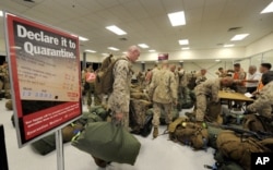 FILE - United States Marines complete quarantine checks as they arrive at a Royal Australian Air Force Base in Darwin.