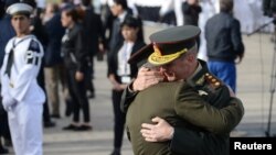 Unidentified members of the Navy embrace as they stand alongside relatives of the 44 crew members of the missing at sea ARA San Juan submarine during a ceremony to commemorate the one year anniversary of the tragedy in Mar del Plata, Argentina, Nov. 15, 2018.