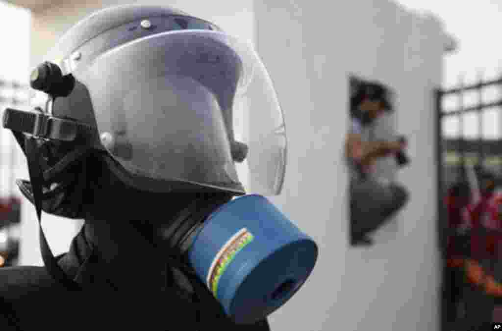 A member of Equatorial Guinea's special police forces wears a gas mask after firing tear gas at Equatorial Guinea fans as they try to get inside the Estadio de Bata "Bata Stadium", which host the opening match and ceremony for the African Nations Cup, in