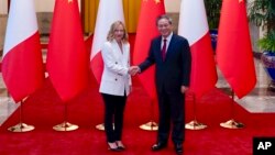 PM Italia Giorgia Meloni (kiri) berjabat tangan dengan Perdana Menteri China Li Qiang di Beijing, Minggu, 28 Juli 2024, menjelang forum bisnis Italia-China. 