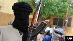 A picture taken on July 16, 2012 shows fighters of the Islamist group Movement for Oneness and Jihad in West Africa (MUJAO) sitting in the courtyard of the Islamist police station in Gao.