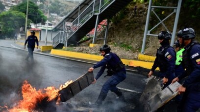 La policía antidisturbios retira una barricada encendida durante enfrentamientos con manifestantes contrarios a los resultados electorales en Venezuela, en Caracas, Venezuela, el 29 de julio de 2024.