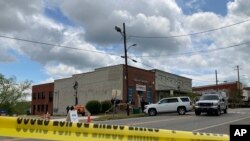 Los investigadores trabajan en el lugar de un tiroteo fatal en el centro de Dadeville, Alabama, el domingo 16 de abril de 2023. Varios murieron durante un tiroteo en una fiesta de cumpleaños el sábado por la noche, dijo la Agencia de Cumplimiento de la Ley de Alabama.