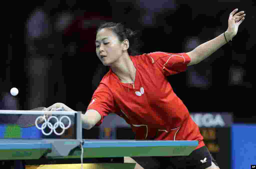 Canada's Mo Zhang returns a shot to Hana Matelova, of the Czech Republic, during their table tennis match at the 2016 Summer Olympics in Rio de Janeiro, Brazil, Aug. 6, 2016.