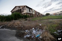 FILE - Garbage litters an abandoned section of an apartment complex destroyed by Hurricane Katrina in 2005, in New Orleans, La., Aug. 6, 2015.