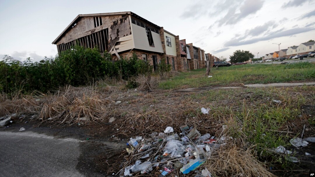 A pile of garbage sits in front of an abandoned section of an apartment complex which was destroyed in 2005 by Hurricane Katrina, in New Orleans, Louisina, Aug. 6, 2015.