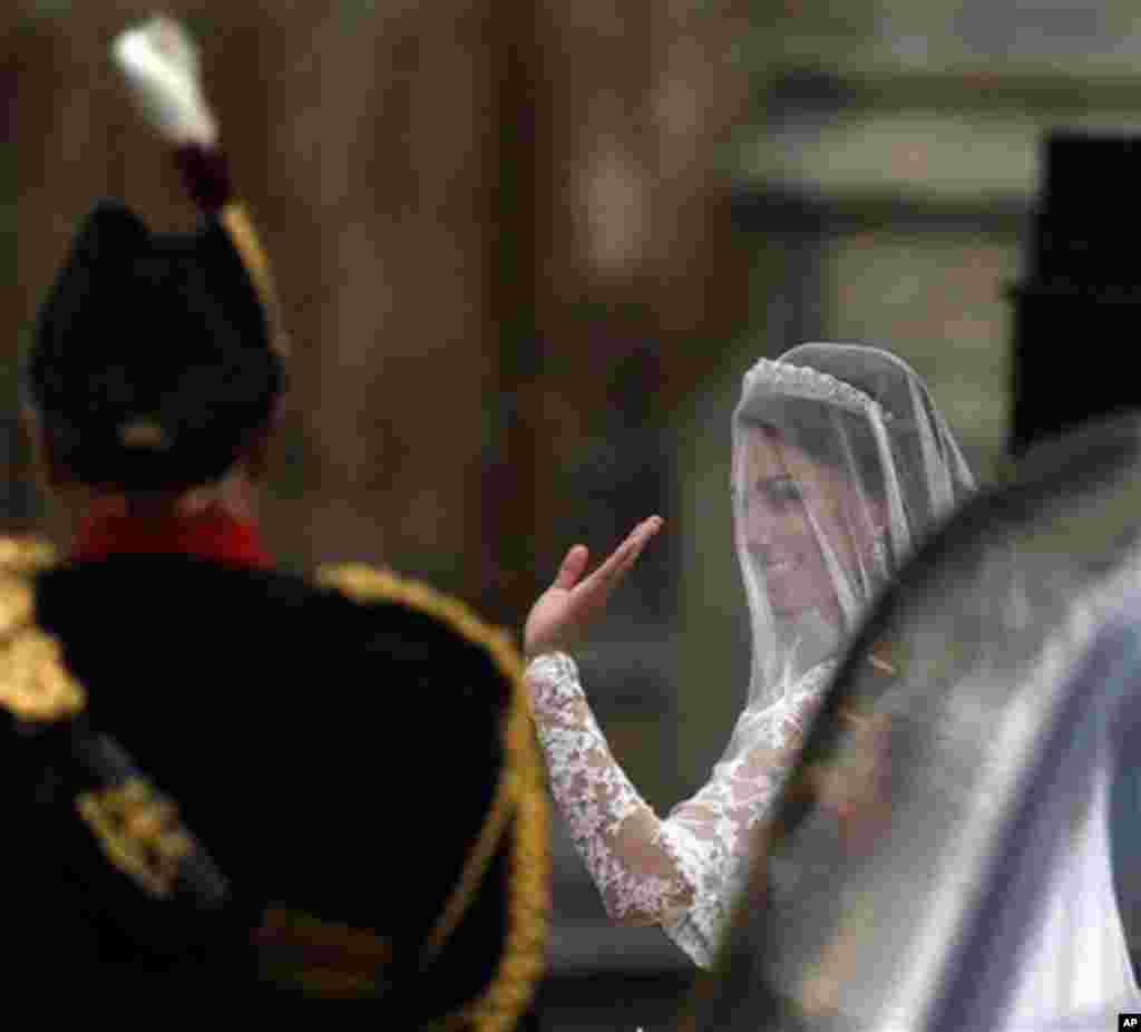 Kate Middleton waves to the crowd upon arriving at Westminster Abbey for her wedding to Britain's Prince William Friday, April 29, 2011 (AP)