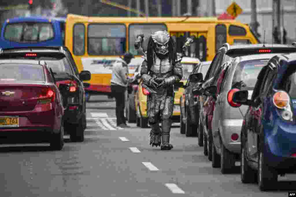 A man in a predator costume walks along an avenue in Bogota, Colombia, March 3, 2021.