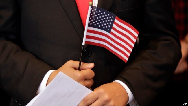 手握美国国旗等待宣誓入美国国籍的人