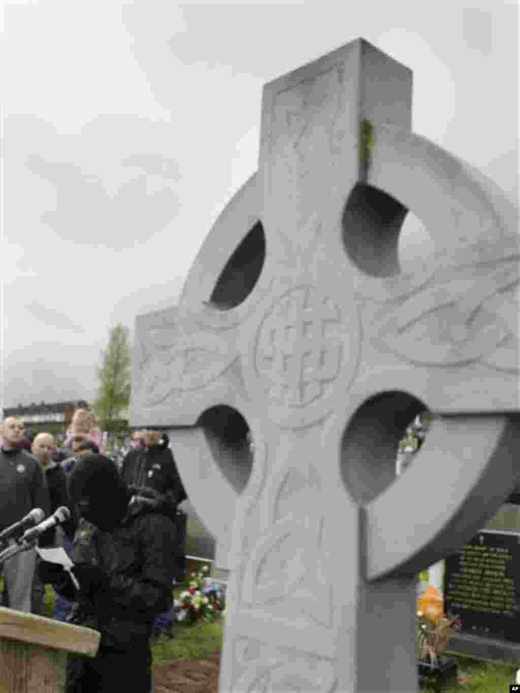 A masked member from the dissident terror group the Real Irish Republican Army (RIRA) reads a statement to supporters at Creggan Cemetery, Londonderry, Northern Ireland, Monday, April 9, 2012. Hundreds of dissident sympathizers gathered Monday for a comm