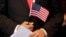 手握美国国旗等待宣誓入美国国籍的人