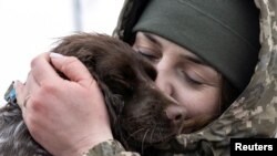 Ukrajinska granična straža i bivša ratna zarobljenica Alina Panina grli svog službenog psa 'Roksi' u Novovoljinsku