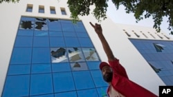 A man stands outside the damaged headquarters of the national oil company after an attack by gunmen in Tripoli, Libya, Sept. 10, 2018. Officials said security forces of Libya's U.N.-backed government stormed the building after gunmen had earlier gone in, 