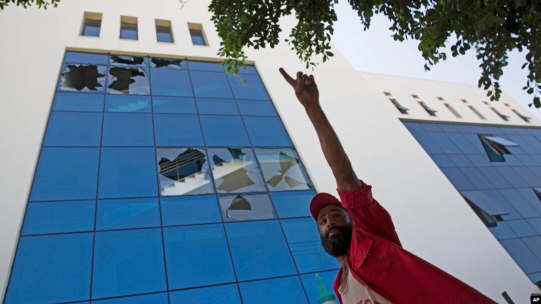 Seorang pria berdiri di luar kantor pusat perusahaan minyak nasional yang rusak setelah diserang sekelompok pria bersenjata di Tripoli, Libya, 10 September 2018.