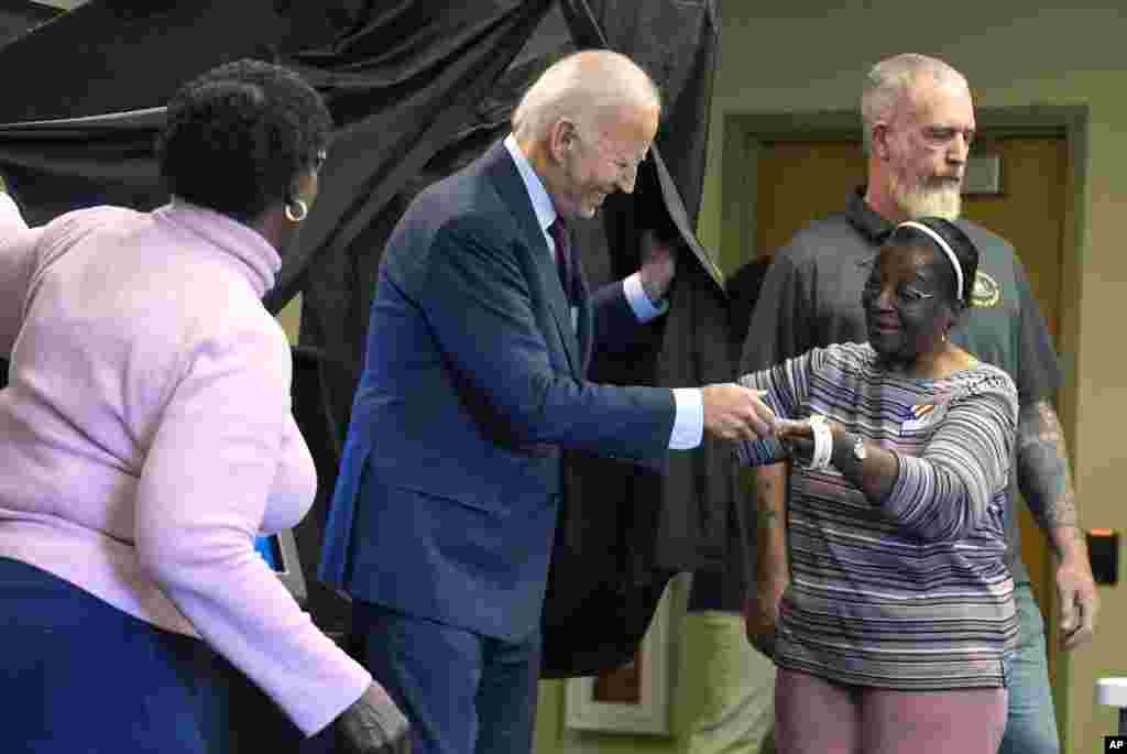 President Joe Biden is handed an &quot;I Voted Early&quot; sticker upon exiting the voting booth after casting his early-voting ballot for the 2024 general elections in New Castle, Delaware.