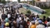 FILE: Crowds of people watch a bus collided with a motorcycle on the outskirts of Phnom Penh, Cambodia, Sept. 24, 2009. 