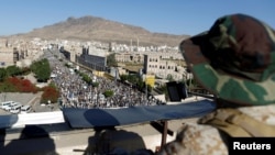 Militan Houthi berjaga di atas atap sebuah gedung saat rekan-rekannya berdemo di Sanaa, Yaman, 5 Oktober 2018. (Foto: dok).