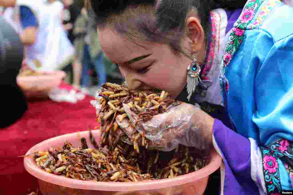 A woman participates in an insect-eating competition in Lijiang, Yunnan province, China, June 25, 2017.