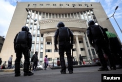 FILE - Egyptian security forces stand guard outside the court during the trial of human rights lawyer and ex-presidential candidate, Khaled Ali in Cairo, Egypt, Jan. 3, 2018.