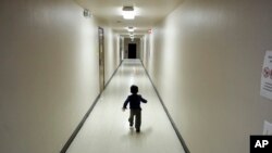 FILE - A boy who was detained with migrants at the U.S.-Mexico border runs down a hallway after arriving from an immigration detention center at a shelter in San Diego, California, Dec. 11, 2018.