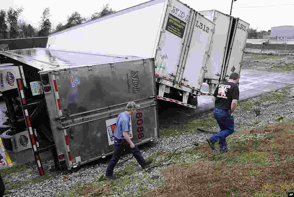 Workers with National Distributors Leasing examine damage to semi trailers following a tornado that went through Hodgenville, Kentucky, February 29, 2012. (AP) 