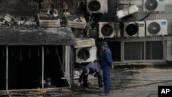 Investigators inspect burnt out corridor following a fire at a hospital in Beijing, April 19, 2023. 