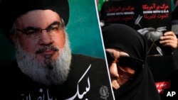 Seorang jamaah Iran mengangkat poster pemimpin Hizbullah Sayyed Hassan Nasrallah, bertuliskan dalam bahasa Arab: "Siap melayani Nasrallah" selama unjuk rasa anti-Israel setelah salat Jumat di Teheran, Iran, 27 September 2024. (Foto: AP/Vahid Salemi)