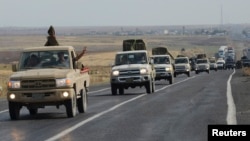 FILE - Convoy of peshmerga vehicles makes its way to the Turkish-Syrian border, near the town of Kiziltepe, in the southeastern Mardin province, Turkey, Oct. 29, 2014.