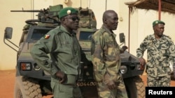 Malian military soldiers stand near an armored vehicle that belongs to the French Army at the Malian military Command Post in Sevare, northeast of the capital Bamako, January 25, 2013.