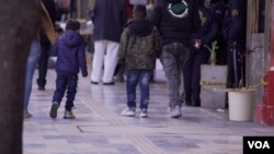 Dos menores de edad caminando junto a sus madres en un centro comercial de Bogotá, el martes 5 de noviembre de 2024. FOTO: Camilo Álvarez, VOA.