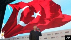 FILE - Turkey's President Recep Tayyip Erdogan talks to supporters of his ruling Justice and Development Party during an event to announce the party's "manifesto" ahead of countrywide local elections scheduled for March 31, in Ankara, Jan. 31, 2019.