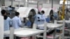上海生产医疗设备的西门子工厂工人戴着口罩在生产线上工作。（2020年2月24日）